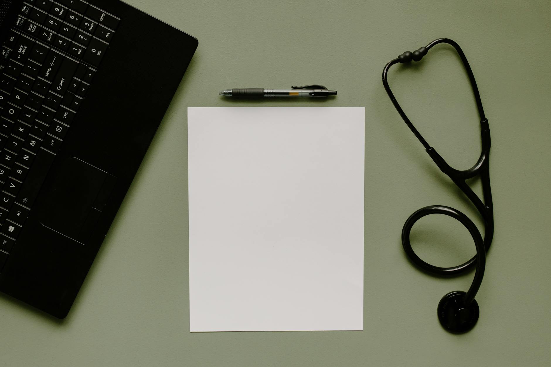 a blank white paper beside ball pen and stethoscope